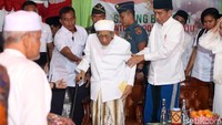 Jokowi memapah KH Maimoen Zubair.