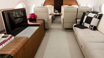 Terlihat kursi santai untuk menonton televisi dan di belakangnya ada deretan kursi lain. Interiornya bisa diubah sesuai keinginan yang empunya. Foto: Gulfstream