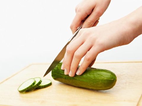 Cutting cucumber on a chopping board