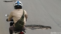 Penampakan pengendara motor saat menghindari lubang saluran air di tengah jalan Sudirman, Jakarta, Sabtu (2/2/2019).