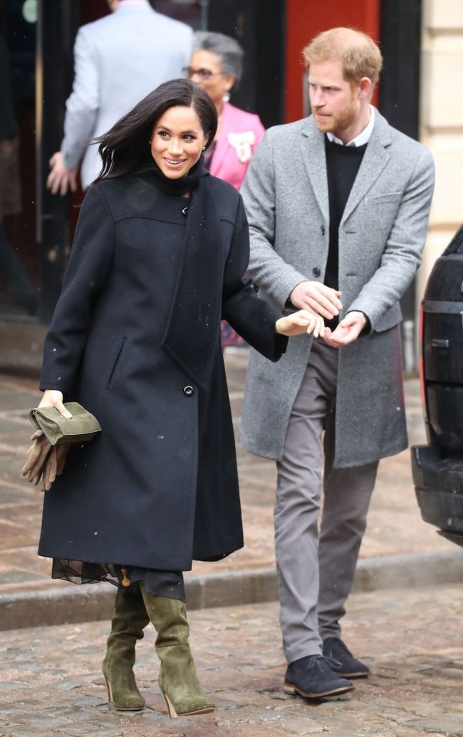 Hujan salju tak menghalangi Meghan untuk tampil maksimal. Untuk menghangatkan tubuhnya dari udara dingin Bristol, Meghan yang tengah hamil enam bulan mengandalkan coat hitam dari William Vintage. Foto: Dok. Getty Images