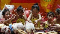 Anak-anak di Filipina antusias bermain dengan beberapa anak babi saat mempersiapkan perayaan tahun baru Imlek. Istimewa/Bullit Marquez/AP Photo.