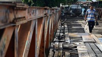 Seorang warga melintasi jembatan kayu yang menghubungkan Jalan Karet Pasar Baru VII, Karet Tengsin dan Jalan Pam Baru, Bendungan Hilir, Tanah Abang.