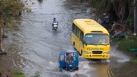 Bus-bus sekolah menerobos banjir di Vietnam, semakin sedikit peminatnya karena bus disana semakin menua dan rusak. Istimewa/Dok. Shutterstock/Anna Lo.