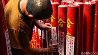 Seorang petugas mempersiapkan ratusan lilin yang akan digunakan untuk perayaan tahun baru Imlek esok hari.