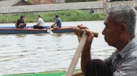 Warga Tangerang menggunakan perahu sampan yang disewanya untuk menyebrangi sungai Cisadane.