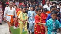 Setelah hujan reda rombongan pun kembali berbaris rapi, dimulai dengan barisan pembawa lilin, anak-anak, dan ibu-ibu yang memanggul persembahan.