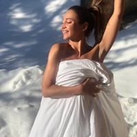 Pada foto lainnya, Olga Buzova juga dengan berani berpose hanya memakai selimut putih. Dia tersenyum ke kamera seolah sama sekali tidak merasa dingin. Foto: Instagram @buzova86