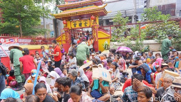 Petugas Linmas bagikan angkpau untuk warga di Vihara Dharma Bakti