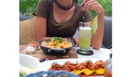 Hamparan makanan ada di depannya, tapi kok Angie malah menoleh? Lihat apa ya? Foto: Instagram @nonangie