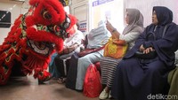 Barongsai beratraksi di dalam gerbong KRL.