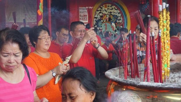 Warga mulai beribadah di dengan menyalakan dupa.