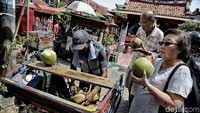 Dua orang warga Tionghoa menikmati air kelapa di depan Klenteng Boen Tek Bio di kawasan Pasar Lama, Kota Tangeranga, Banten.