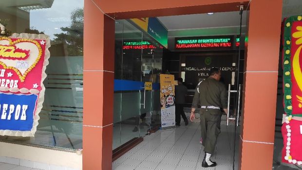 Pintu kaca yang pecah tampak melompong dan belum diperbaiki.