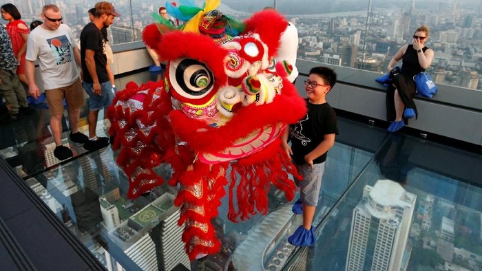 Barongsai beraksi di lantai kaca Skywalk untuk merayakan Tahun Baru Imlek di Thailand, yang juga merupakan negara libur Imlek.