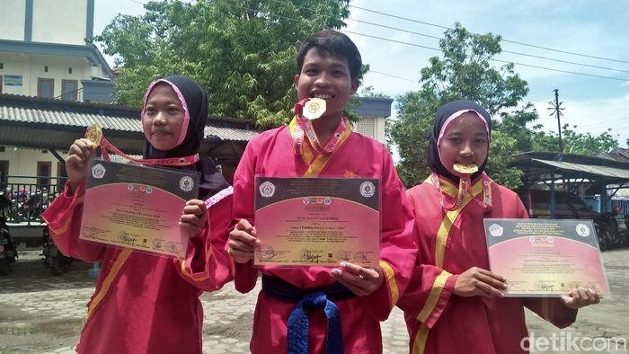 Putri, Luluk, dan Rudi berhasil menggondol medali emas dari kejuaraan pencak silat Paku Bumi Terbuka 2019. (Arif Syaefudin/detikSport) Putri, Luluk, dan Rudi berhasil menggondol medali emas dari kejuaraan pencak silat Paku Bumi Terbuka 2019. (Arif Syaefudin/detikSport)