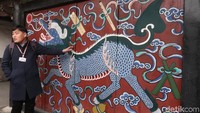 Lukisan ini menggambarkan naga yang terbang untuk merengkuh bulan. Naga yang serakah ingin memiliki bulan. Namun tak sampai bulan, naga tersebut mati dan hilang ke dalam lautan. (Bonauli/detikTravel)