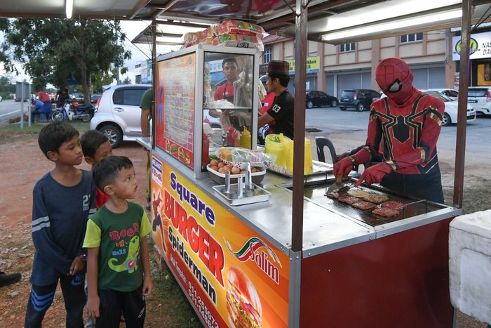 BESUT, 5 Feb -- Fakhrul Fahmie Ishak, 18, (kanan) yang menggayakan kostum adiwira Spiderman menjadi tarikan ketika membantu abangnya Ahmad Ridhuan, 22, menyediakan pesanan burger di Kampung Raja baru-baru ini.
Idea untuk menggunakan kostum adiwira tersebut merupakan strategi kreatif Ahmad Ridhuan yang memulakan perniagaan tersebut pada akhir Disember tahun lepas bagi memastikan bertambah maju.
--fotoBERNAMA (2019) HAK CIPTA TERPELIHARA