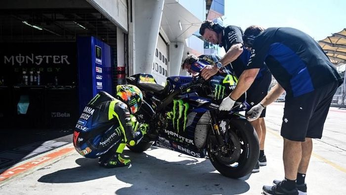 Valentino Rossi sedang mengecek motor YZR-M1. Yamaha di MotoGP 2019 tengah kesulitan, dengan tertinggal dari para rivalnya. (Foto: Mohd RASFAN / AFP)