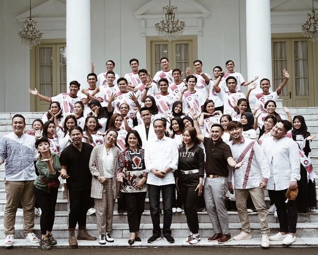 Ibu tiga anak ini memadukan blus bergaya tunik tersebut dengan celana panjang hitam. Tidak ketinggalan pointed heels hitam model selop sebagai alas kaki andalan. Adapun Jokowi bergaya semi formal dengan kemeja putih berpadu jeans dan sneakers hitam. (Foto: Instagram/@carendelano)