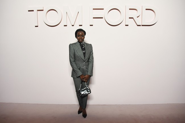 Blazer abu-abu bergaya klasik menjadi pilihan bintang Black Panther Danai Gurira. Untuk bawahan, ia mengandalkan celana panjang sehingga mempertegas kesan maskulinnya. (Foto: Getty Images)