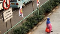 Potret seorang warga yang memilih menyeberang sembarangan di kawasan Jalan Otto Iskandardinata, Jakarta Timur, Jumat (8/2/2019).