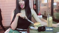 Makan burger dengan segelas minuman segar, Pamela tampil cantik dan modis saat makan di restoran yang Instagrammable. Foto: Instagram @pamelaaasafitriduoserigala