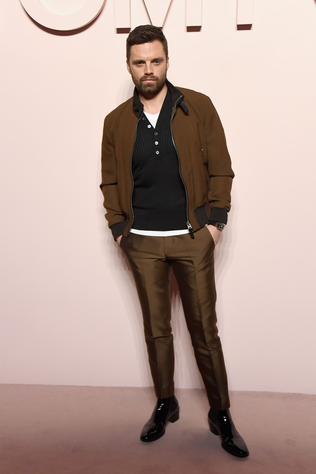 Memilih busana bernuansa kecoklatan, bintang Avengers: Infinity War Sebastian Stan tampil stylish dengan padanan jaket bomber dan celana panjang satin. (Foto: Getty Images)