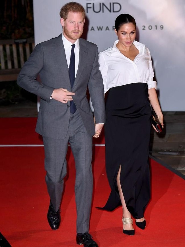 Pointed heels hitam dengan aksen keemasan dari Aquazzura dan clutch Givenchy senada turut menyempurnakan gaya Meghan. (Foto: Getty Images)