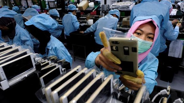 FILE PHOTO - A worker holds an OPPO F1S smartphone at an OPPO smartphone factory in Tangerang, Indonesia, September 20, 2016. REUTERS/Beawiharta/File Photo   GLOBAL BUSINESS WEEK AHEAD