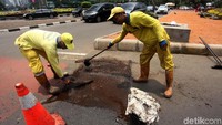 Petugas dari Sudin Bina Marga menambal jalan yang berlubang di Thamrin, Jakarta Pusat.