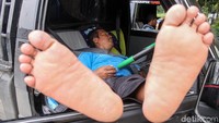 Seorang sopir truk tertidur di mobilnya saat beristirahat di rest area KM 86 Tol Trans Jawa jalur Jakarta-Semarang.
