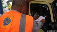 Salah satu petugas memberikan surat tilang yang dilayangkan petugas kepada sopir yang masih nakal.