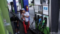 Petugas SPBU melayani sopir truk yang akan mengisi BBM.