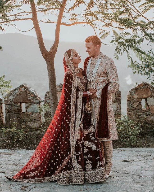 Busana India yang digunakan Diipa dan Oleg datang dari Sabyasachi, brand yang sama dengan baju pernikahan Priyanka Chopra dan Nick Jonas. Foto: Instagram (@diipakhosla, @olegbuller)