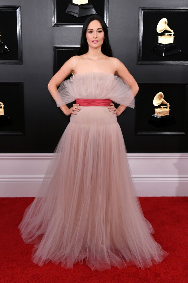 Gaun romantis lainnya dikenakan Kacey Musgraves. Gaun romantis dari tulle ini semakin memikat berkat sabuk warna merah yang kontras. Gaun cantik itu merupakan koleksi Valentino. Foto: Getty Images