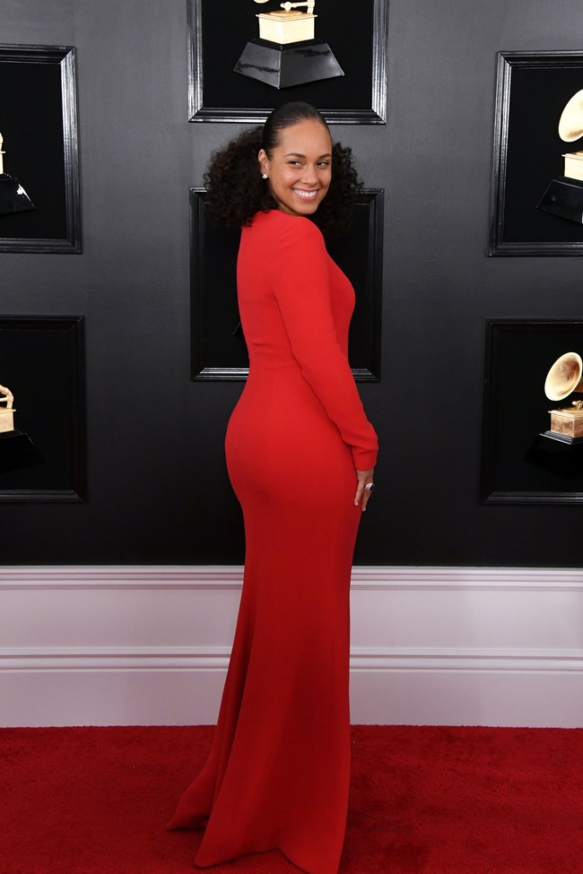 Di karpet merah Grammy Awards 2019, ia tampil mengenakan jumpsuit merah berdada rendah. Ia tampak tidak mengenakan eyeshadow atau bulu mata palsu. Hanya sedikit blush dan lip gloss. Foto: Getty Images
