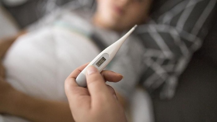 Mother checking her sick sons temperature