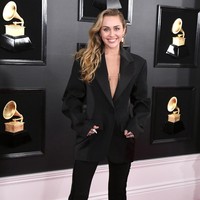Miley Cyrus tidak memilih gaun untuk penampilan karpet merahnya pasca dinikahi Liam Hemsworth. Miley kali ini tampil maskulin dengan setelan oversized rancangan Mugler. Foto: Getty Images