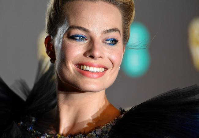 Selain dress Chanel, penampilan Margot Robbie semakin memukau dengan riansan wajah dan rambut. Ia menerapkan tatanan rambut updo yang chic dengan aksen twist dan makeup beraksentuasi eyeshadow biru elektrik.   Foto: Getty Images