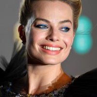 Selain dress Chanel, penampilan Margot Robbie semakin memukau dengan riansan wajah dan rambut. Ia menerapkan tatanan rambut updo yang chic dengan aksen twist dan makeup beraksentuasi eyeshadow biru elektrik.   Foto: Getty Images