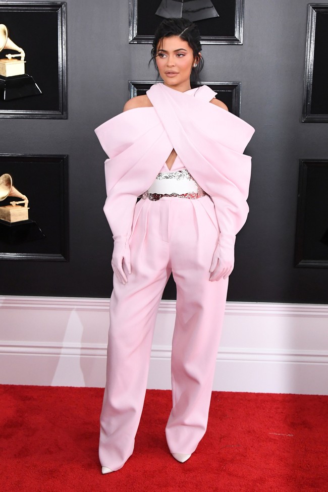 Kylie Jenner mencoba gaya yang tak biasa di penampilan Grammys kali ini dibalut busana dari Balmain. Sayangnya, siluet oversized dan struktural dari jumpsuit dengan bagian lengan menyambung hingga sarung tangan ini malah membuat Kylie tenggelam dalam busananya. Belum lagi guntingan yang membuat bahu Kylie terkesan turun. Foto: Getty Images