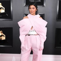 Kylie Jenner mencoba gaya yang tak biasa di penampilan Grammys kali ini dibalut busana dari Balmain. Sayangnya, siluet oversized dan struktural dari jumpsuit dengan bagian lengan menyambung hingga sarung tangan ini malah membuat Kylie tenggelam dalam busananya. Belum lagi guntingan yang membuat bahu Kylie terkesan turun. Foto: Getty Images