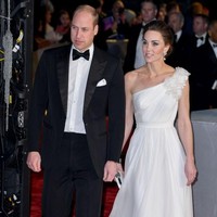 Tidak ketinggalan clutch putih dan sepasang heels Jimmy Choo turut memaksimalkan gaya Kate malam itu. Untuk hair-do, ibu tiga anak ini memilih gaya chic bun yang mempertegas kesan elegansinya. Foto: Getty Images