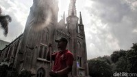 Petugas pemadam kebakaran membersihkan area pelataran Gereja Katedral, Jakarta, Selasa (12/2/2019).