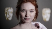 Eleanor Tomlinson juga tampil cerah dengan gaun merah muda. Foto: Gareth Cattermole/Getty Images