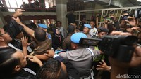 Meski sama-sama berwarna hitam, namun kali ini bukan blankon yang menutupi kepala plontos Dhani. Melainkan peci hitam yang ia kenakan. Kita lihat saja nanti dalam persidangan ketiga apa yang dikenakan?