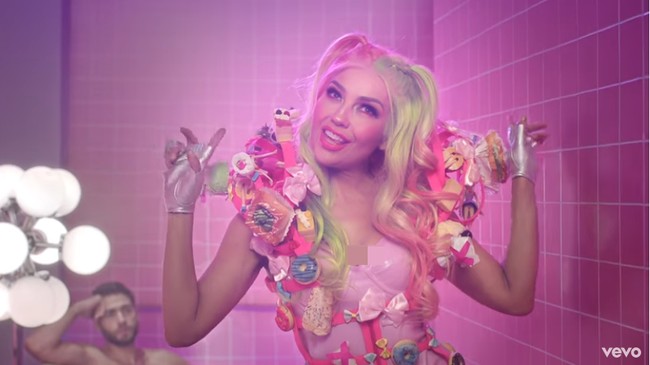 Thalia tampil seperti boneka Barbie dengan riasan wajah bernuansa pink. Semakin menambah kesan muda pada gayanya. Foto: Screenshot YouTube/ Thalia