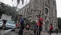 Sejumlah petugas pemadam kebakaran menyapu dan membersihkan area pelataran Gereja Katedral Jakarta.