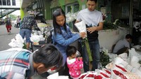 Pedagang bunga mawar tampak sibuk melayani pembeli.